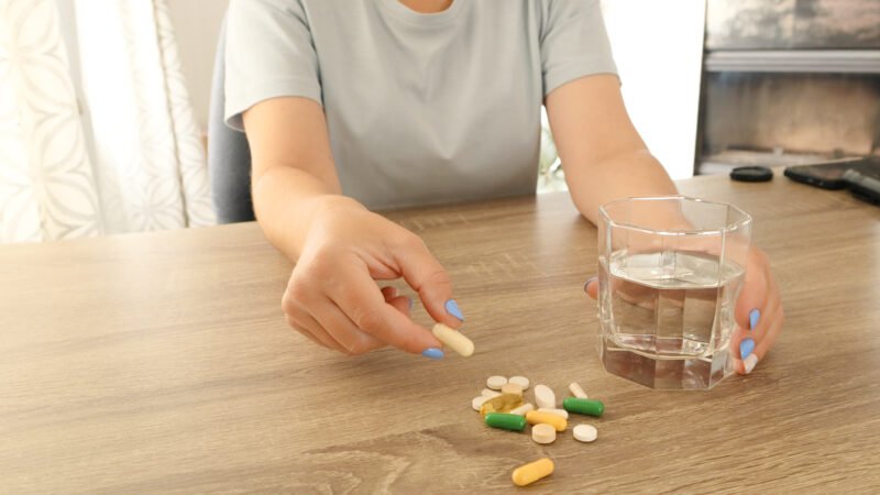 مجموعة فيتامينات للأطفال على طاولة مع خلفية ملونة